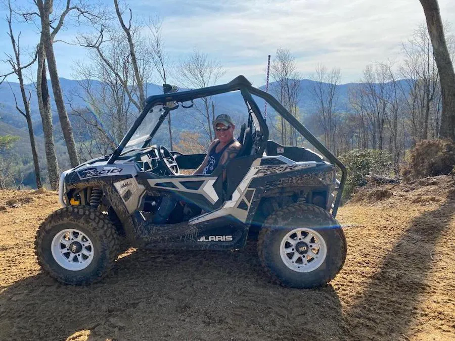 A blue Polaris RZR parked at the overlook with its driver inside